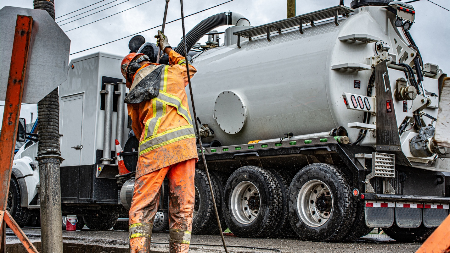 Utility worker holding Hydro vac machine.